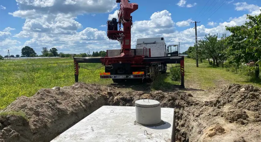 Montaż szamba betonowego w wykopie. Dostępne różne rodzaje szamb, ten jest w trakcie instalacji.