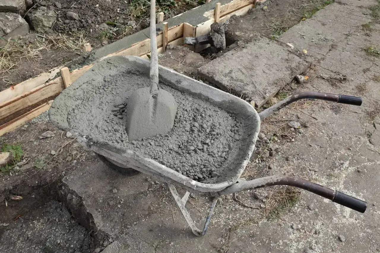 Taczka z betonem i łopatą, gotowa do wylania zbrojenia ławy fundamentowej 40x60.